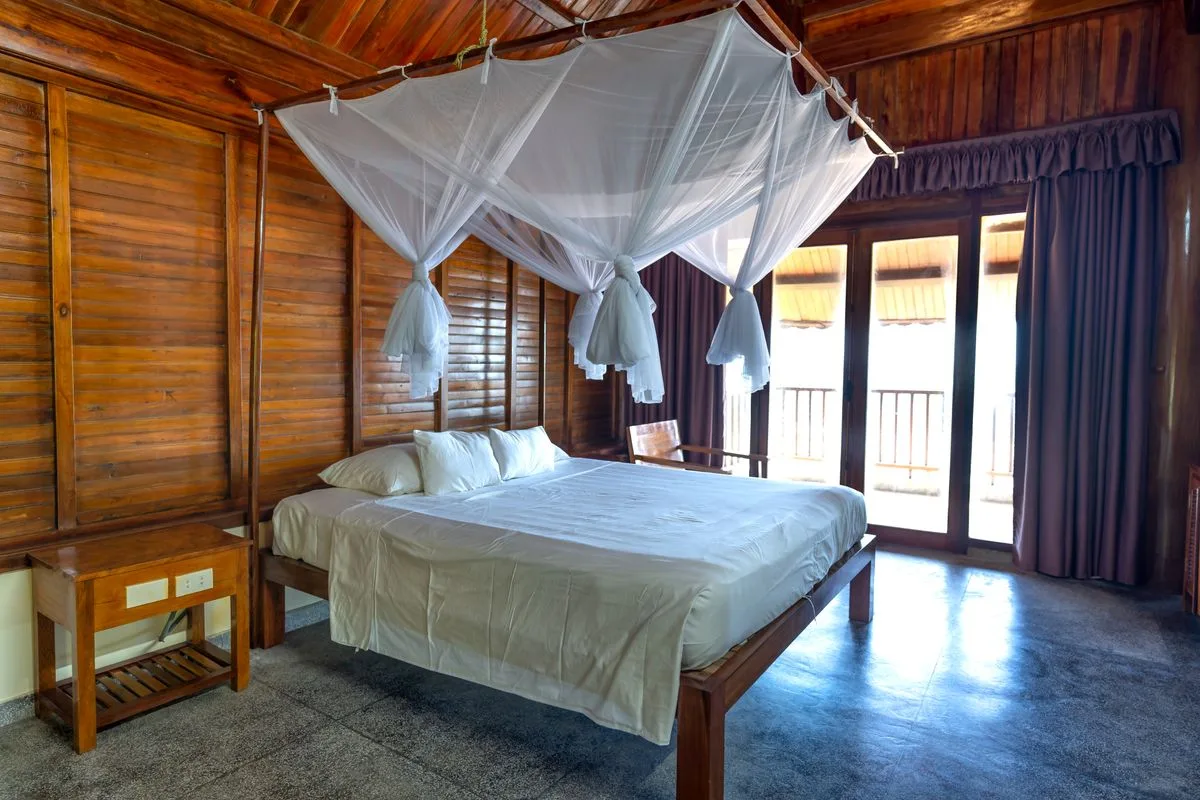 La chambre côté balcon, ouverte sur la lumière du matin — Suite Panoramique, Hôtel Olympe Libreville