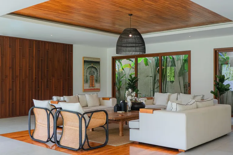 Le salon séparé de la suite, plafond en bois et mobilier en rotin